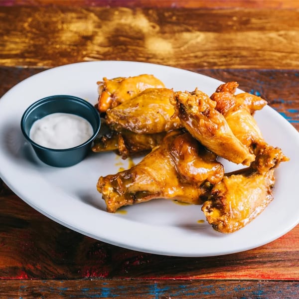 Cantina Taco & Tequila Bar's golden-brown chicken wings with a side of creamy dipping sauce.