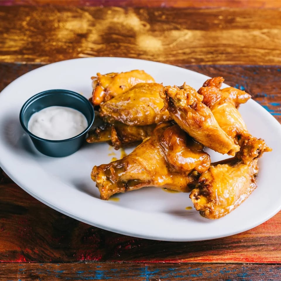 Cantina Taco & Tequila Bar's golden-brown chicken wings with a side of creamy dipping sauce.